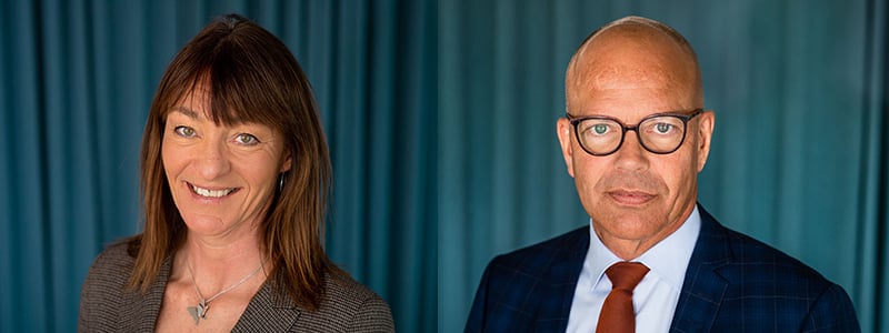 En kvinna och en man framför ett blått draperi.