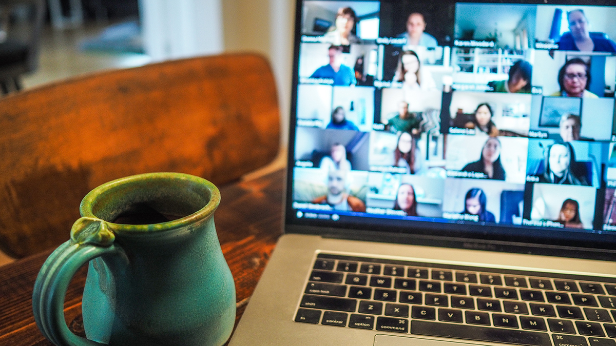 Digitalt möte på laptop med kaffekopp bredvid.