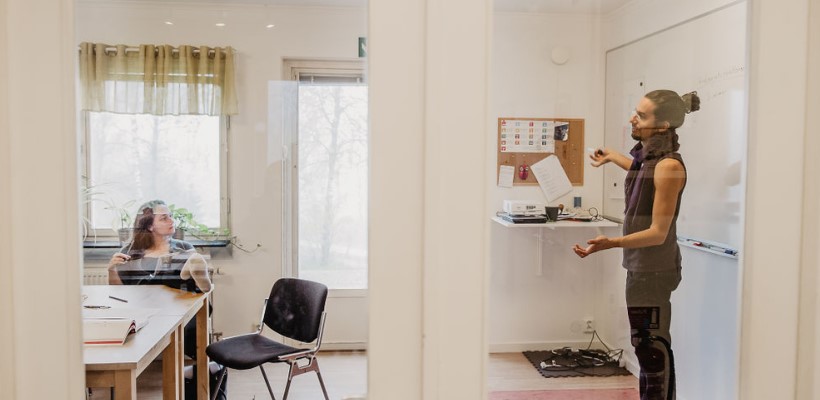 Fyra unga deltagare på folkhögskola skrattar tillsammans.