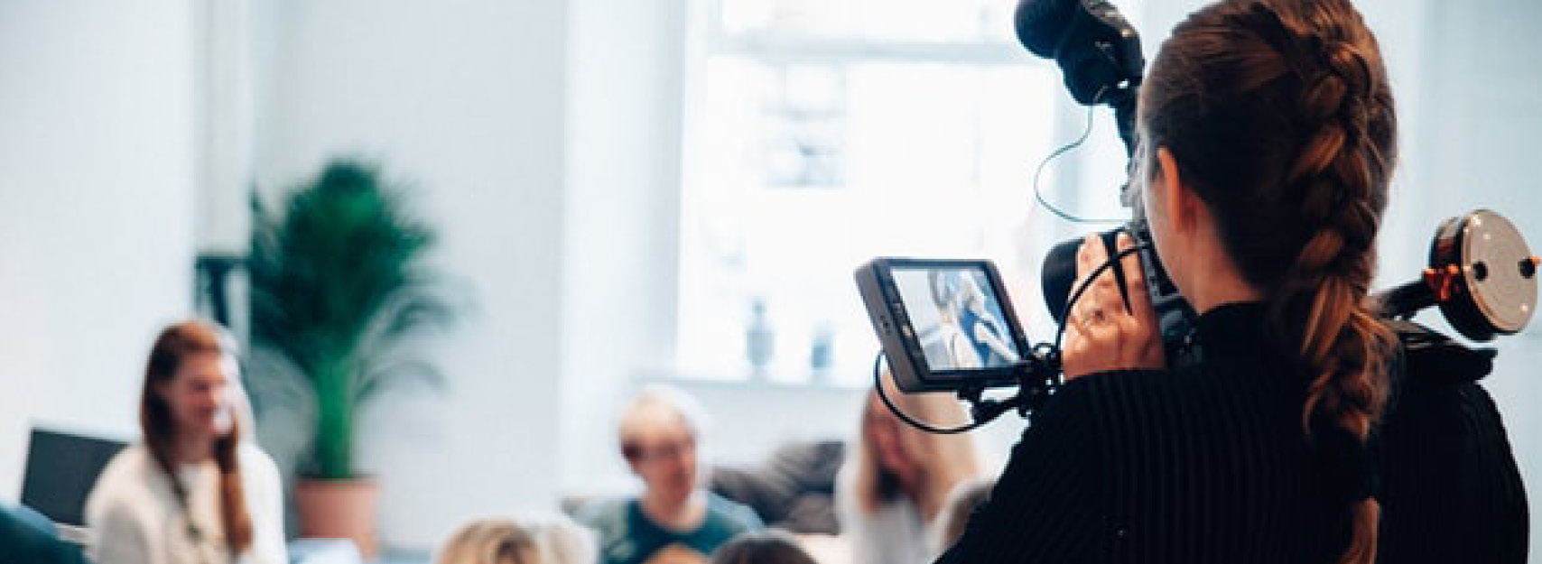 Person filmar en grupp med en videokamera.